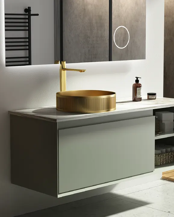 Gold stainless steel countertop basin mounted on a green vanity cabinet