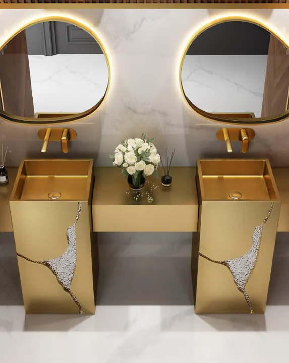 Twin gold stainless steel pedestal basins with round mirrors for a hotel bathroom project